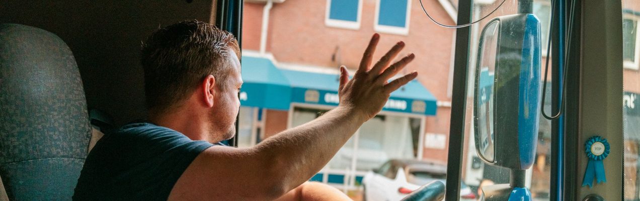 CE-chauffeur van Kattenberg zwaait vanuit de cabine